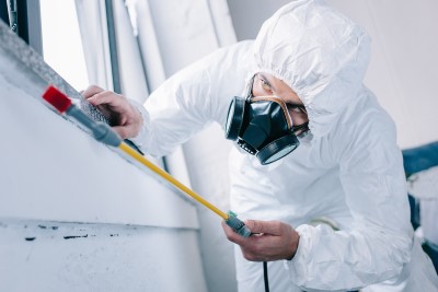 dubai pest control worker in respirator spraying presticides